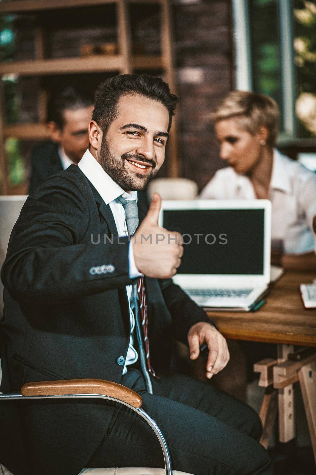 Well-dressed Smiling Man Showing Thumbs Up Gesture, Cheerful Businessman Show Thumbs Up Sign While Sitting At Meeting And Using Laptop, Business Success Concept, Toned Image
