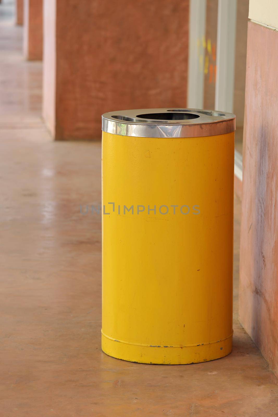 yellow metal cylinder bin on the sidewalk