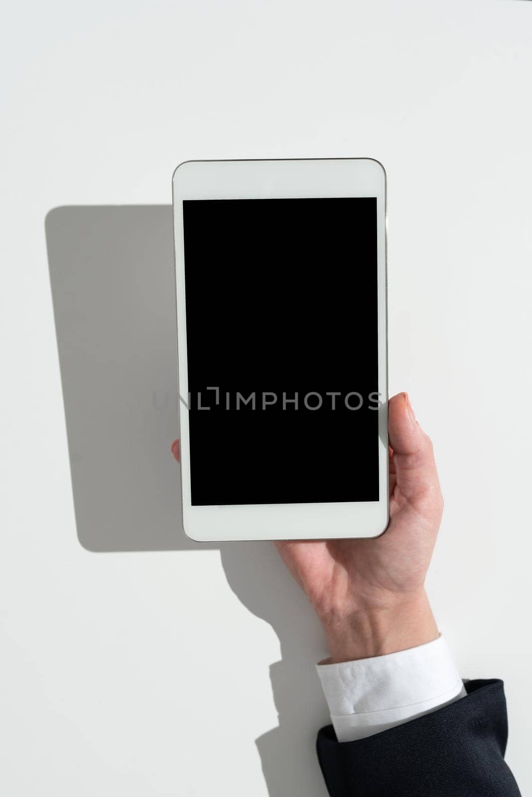 Businesswoman Holding Tablet And Presenting Important Informations On It. Woman Showing Recent Updates On Screen. Executive Displaying Late Achievements On Cellphone. by nialowwa