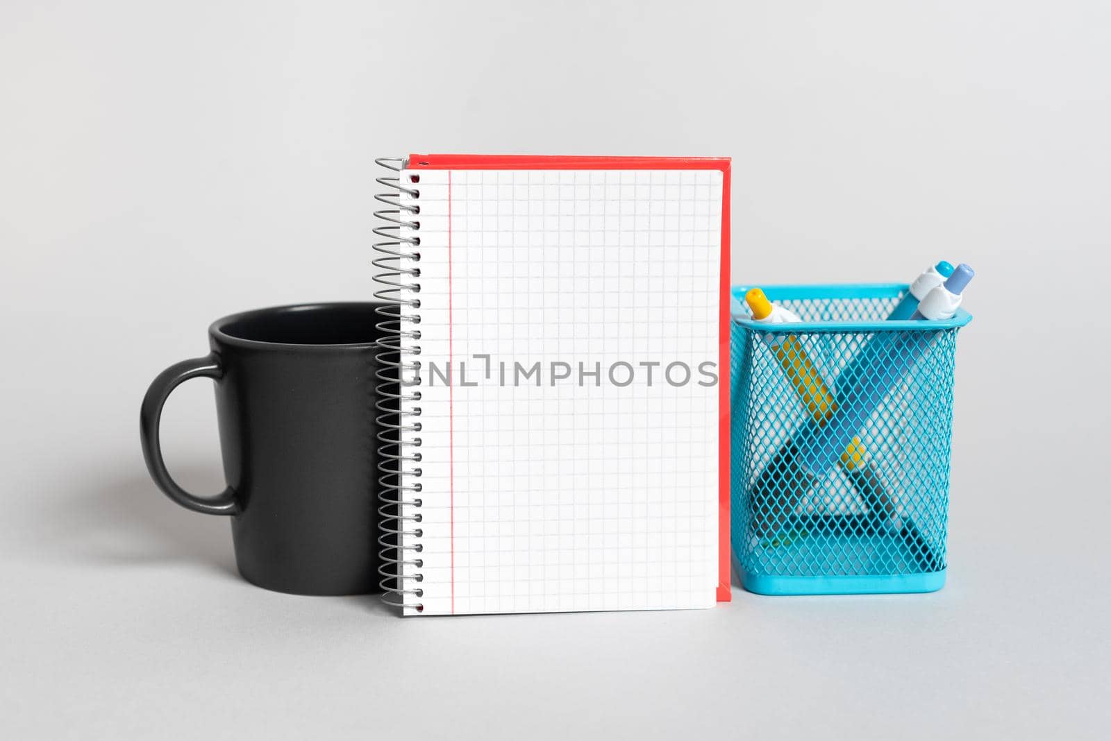 Cup, Notebook With Important Message And Pencil Case On Desk. Mug, Note With Crutial Information And Pens. Glass, Critical Announcement Written On Paper And Pencils. by nialowwa