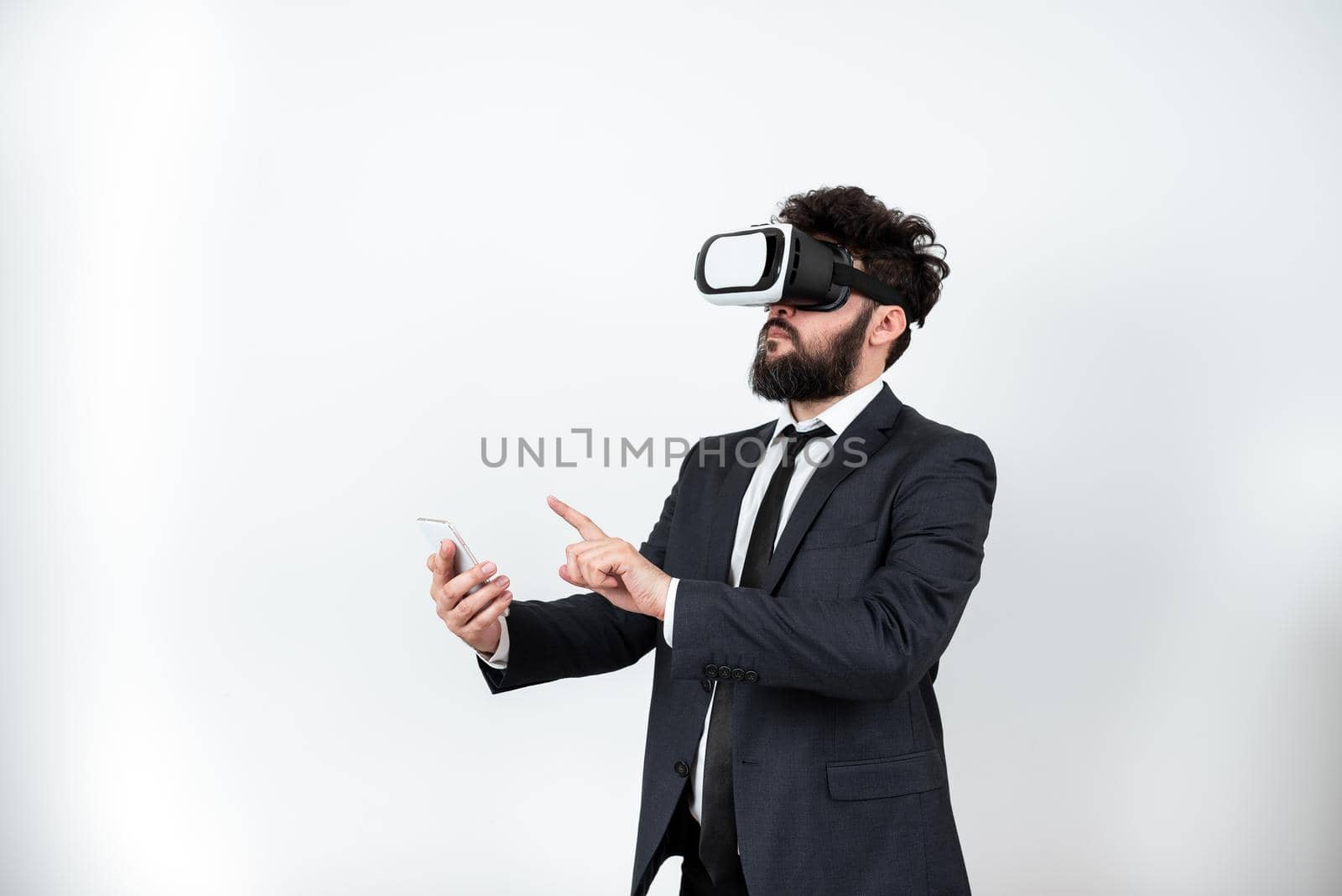 Man Wearing Vr Glasses And Pointing On Important Messages With One Finger. Businessman Having Virtual Reality Eyeglasses And Showing Crutial Informations. by nialowwa