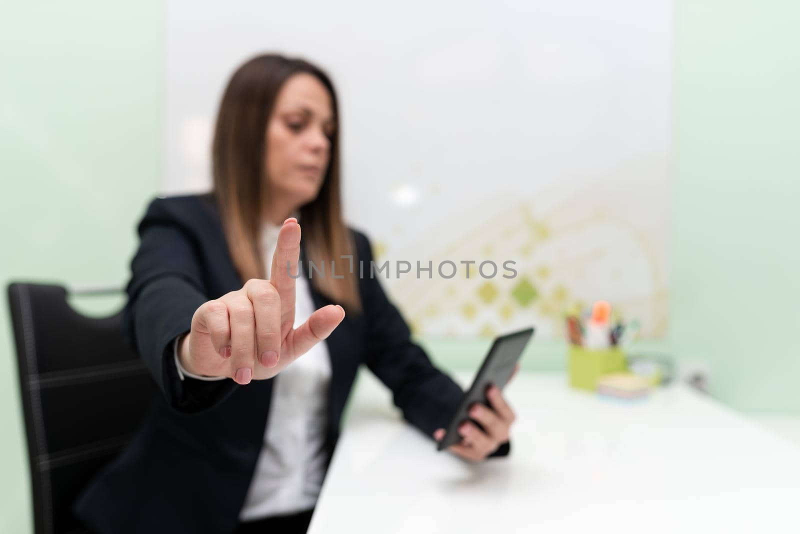 Businesswoman Holding Tablet With One Hand And Pointing Important Ideas With One Finger. Woman With Phone Showing Recent Updates. Executive Displaying Late News. by nialowwa