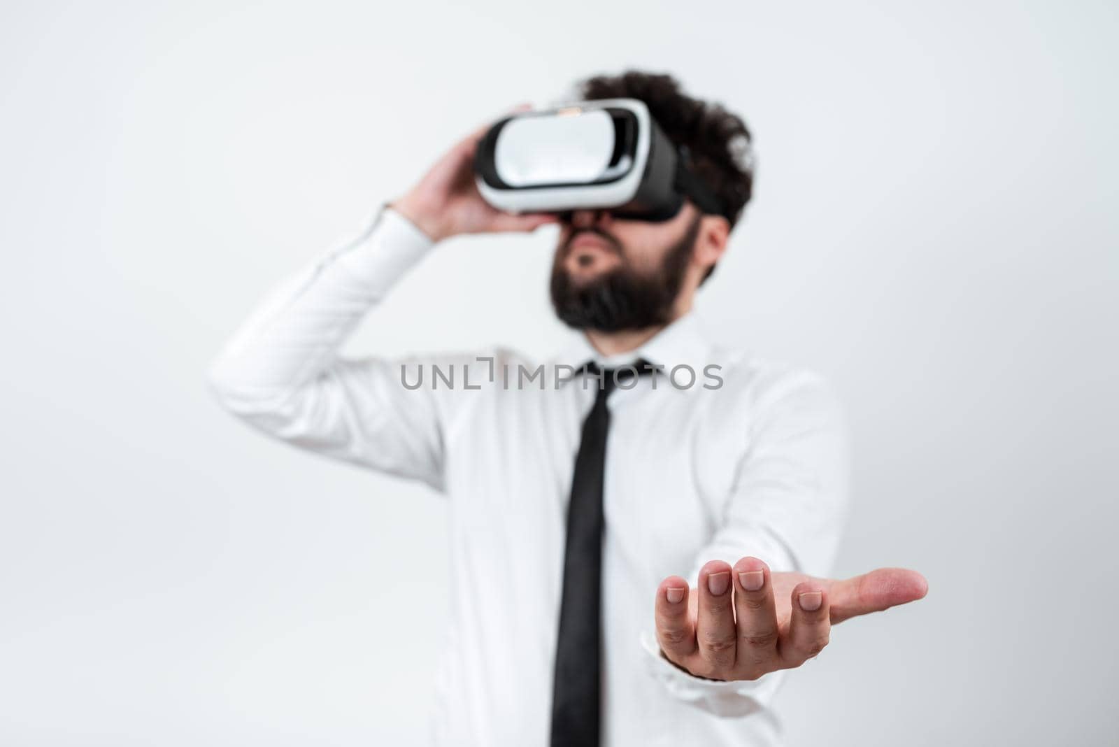 Man Wearing Vr Glasses And Presenting Important Messages Over One Hand. Businessman Having Virtual Reality Eyeglasses And Showing Crutial Informations Above Palm. by nialowwa