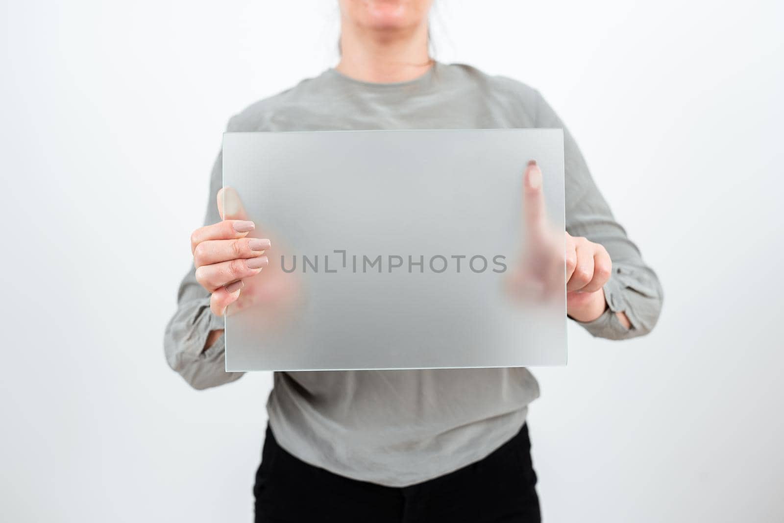 Businesswoman Holding Blank Placard And Presenting Important Sales Data. Female Worker Wearing Smart Casual And With Banner In Hands Advertising The Business. by nialowwa