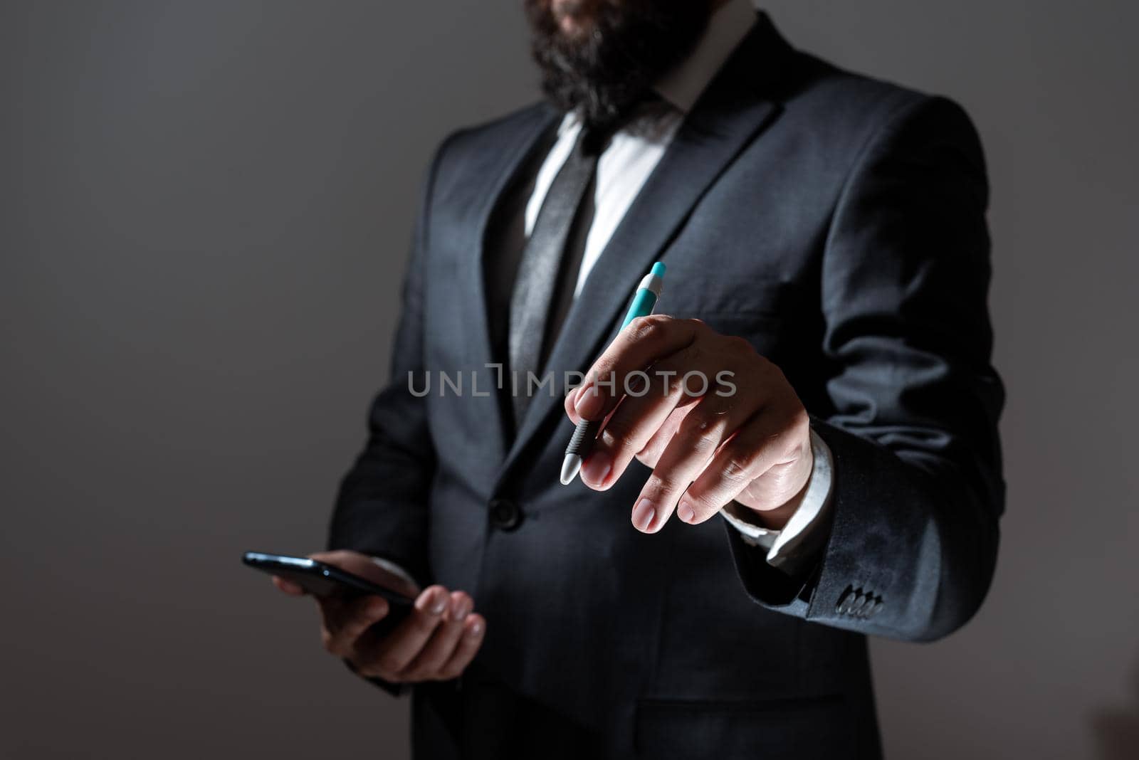 Businessman Holding Tablet And Pointing With Pen On Important Message. Executive In Suit Presenting Crutial Information. Gentleman Showing Critical Announcement. by nialowwa