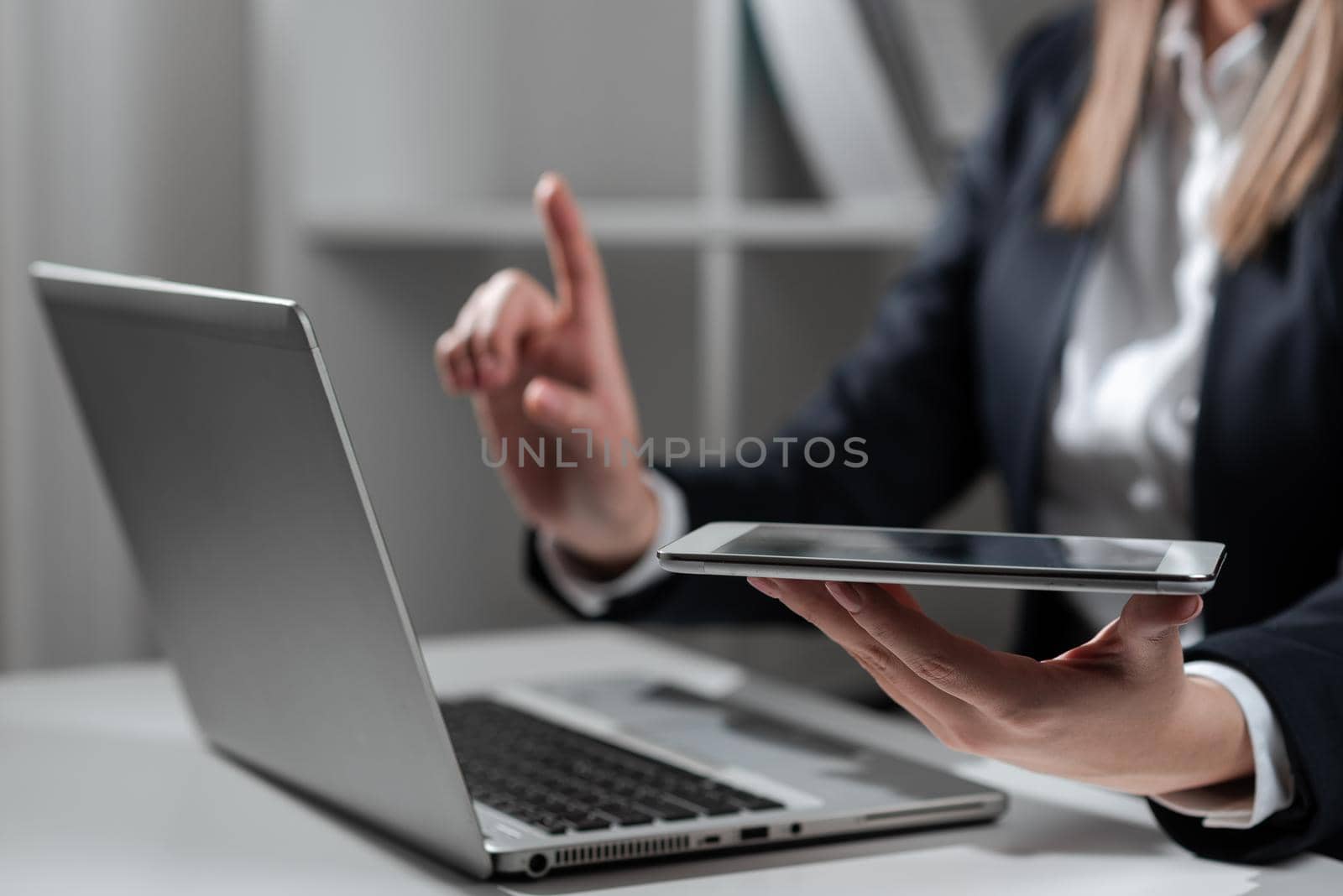 Woman Holding Tablet In One Hand And Pointing On News With One Finger.