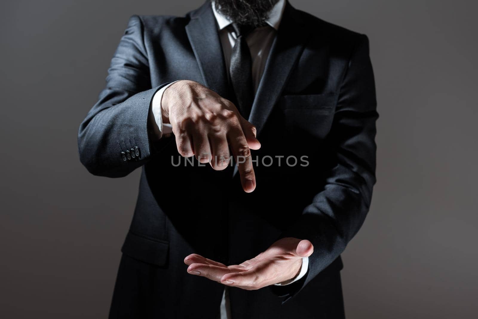 Businessman Pointing With One Finger On Important Messages. Executive In Suit Presenting Crutial Informations. Gentleman Showing Critical Announcement. by nialowwa