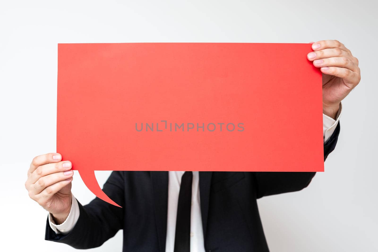 Businessman Holding Speech Bubble With Important Messages. Man In Suit Presenting Crutial Informations On Dialogue Balloon. Gentleman Showing Recent Updates On Paper. by nialowwa