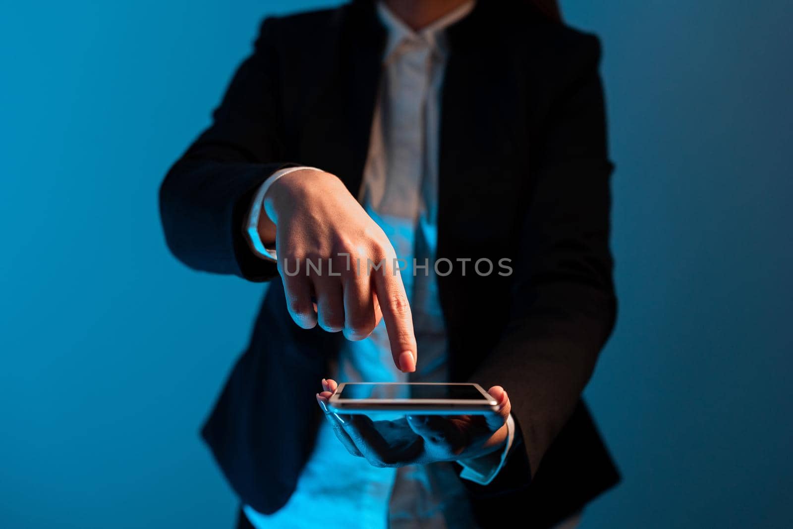 Businesswoman Holding Tablet And Pointing With One Finger On Important Message. Executive In Suit Presenting Crutial Information. Woman Showing Critical Announcement. by nialowwa