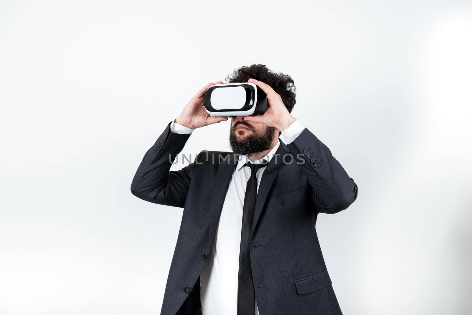 Standing Man Wearing Vr Glasses Presenting Important Messages. Businessman Having Virtual Reality Eyeglasses And Showing Crutial Informations. Male Seeing New Ideas. by nialowwa