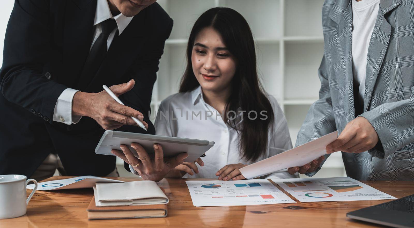 Business team are meeting and discussing marketing plan and pointing graph report analyzing financial figures denoting the progress in the work by nateemee