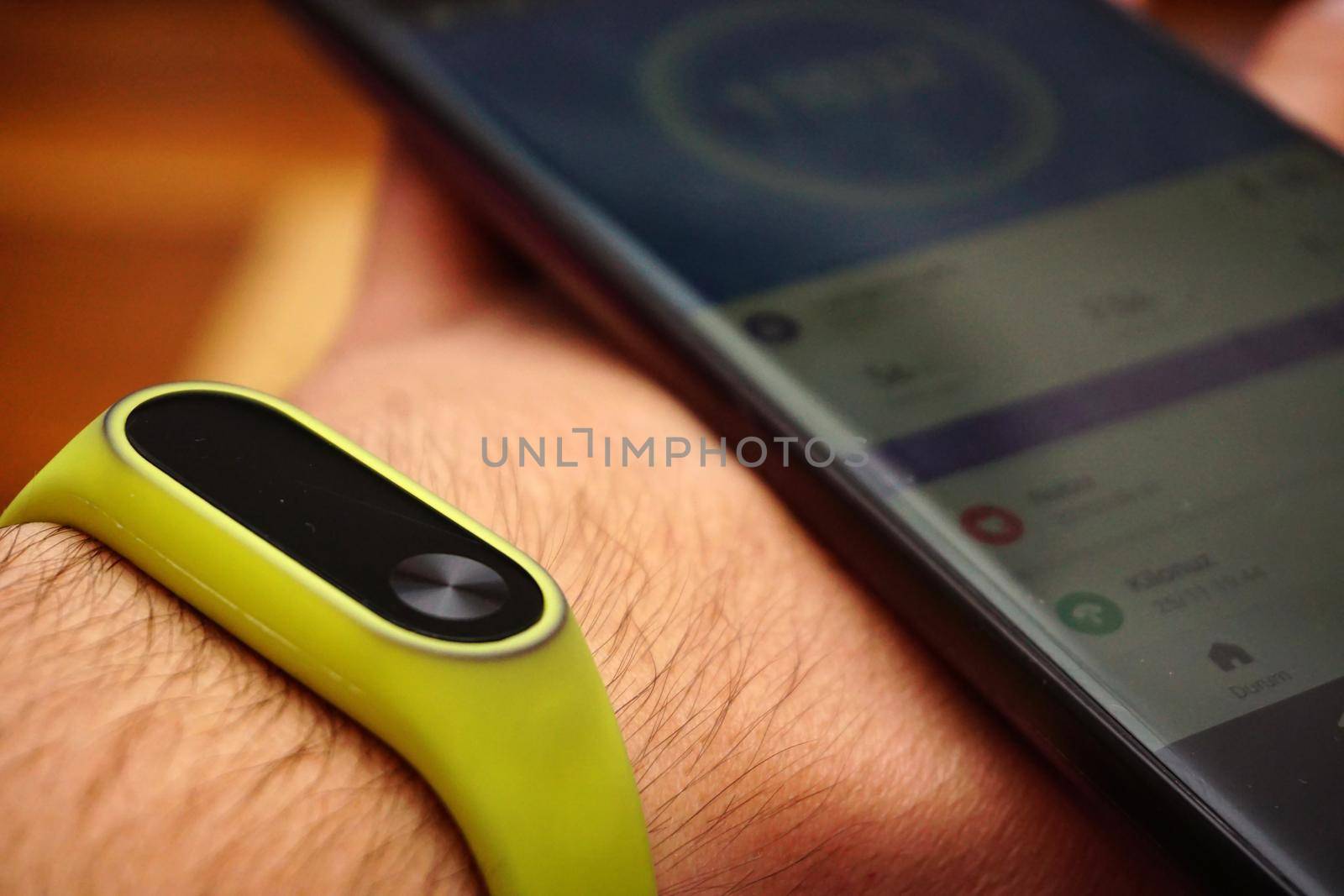 Smartphone and fitness activity tracker bracelet on the wrist close up view