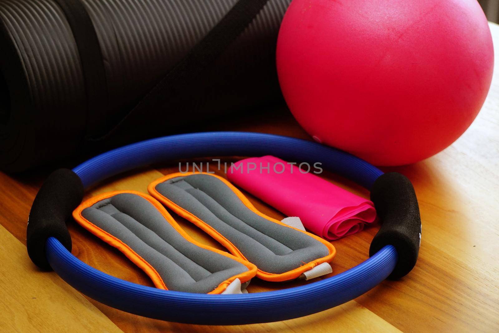 Pilates set with mat stretch ball on wooden background