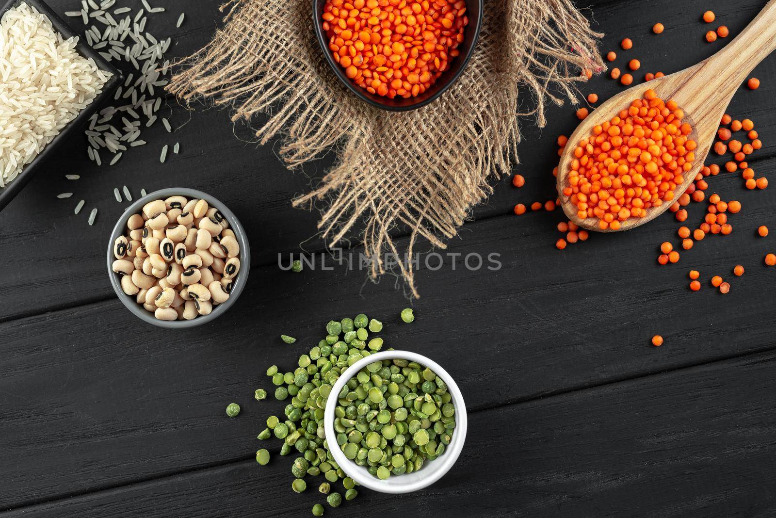 Superfood. Healthy, gluten-free meals. Ancient grain food set. Green peas, amaranth, lentils, chickpeas, black eye beans on a black wooden background. Top view.