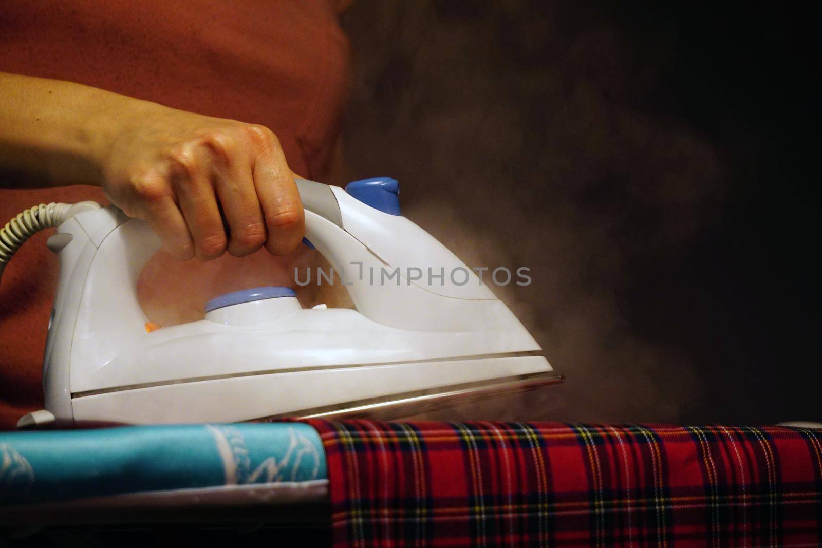 Household ironing at home hands on the iron by tasci