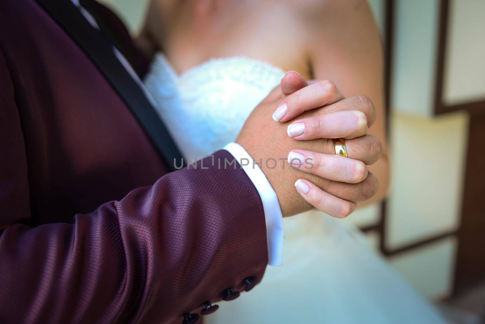 Bride and groom holding hands with engagement rings on their fingers close up view wedding shoot concept