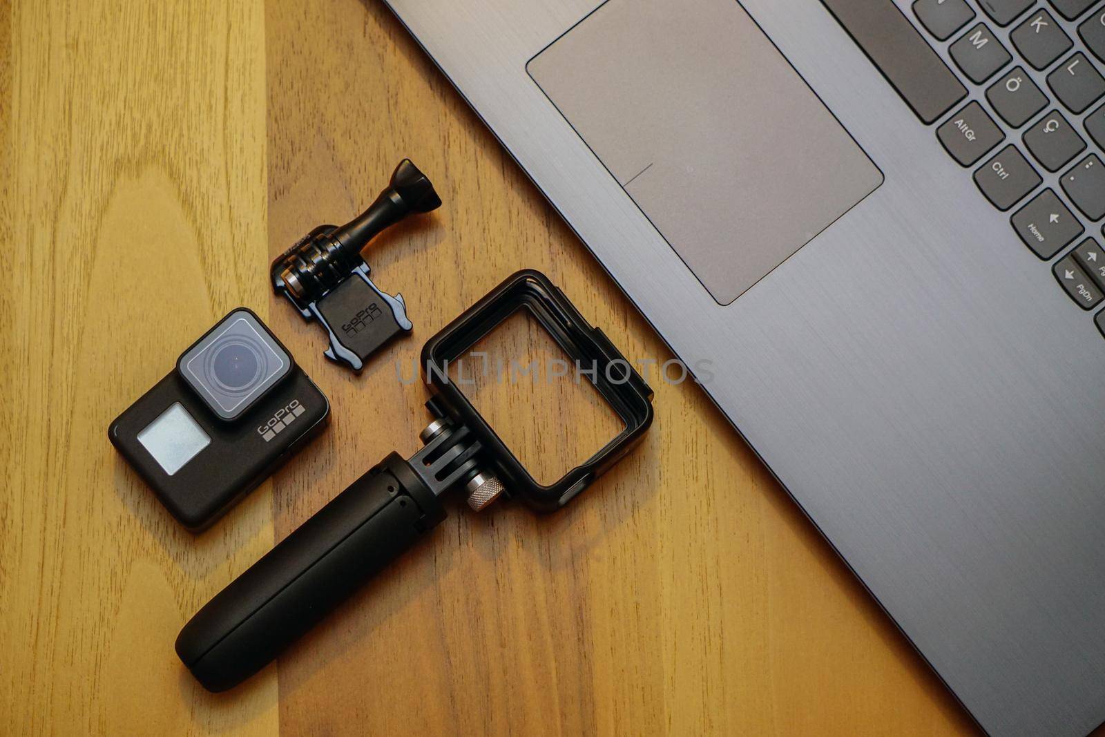 16 May 2019 Eskisehir, Turkey. Gopro 7 black assorted accessories and laptop on wooden background
