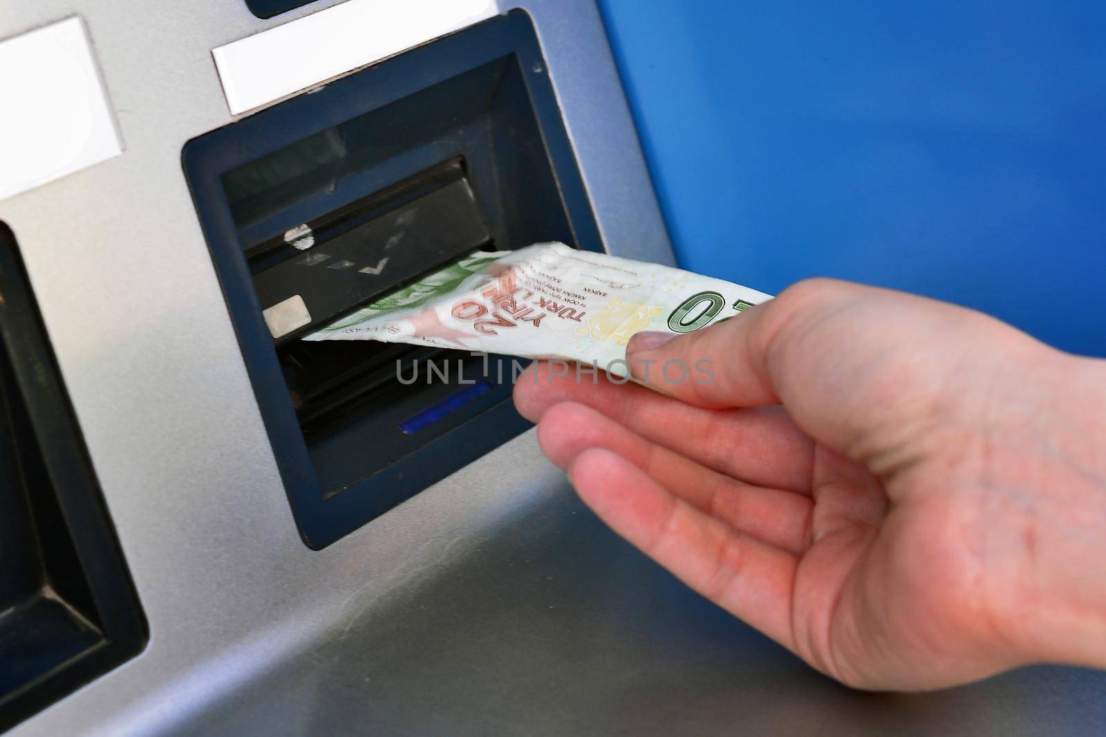 Inserting Turkish lira into the kiosk with hand close up view