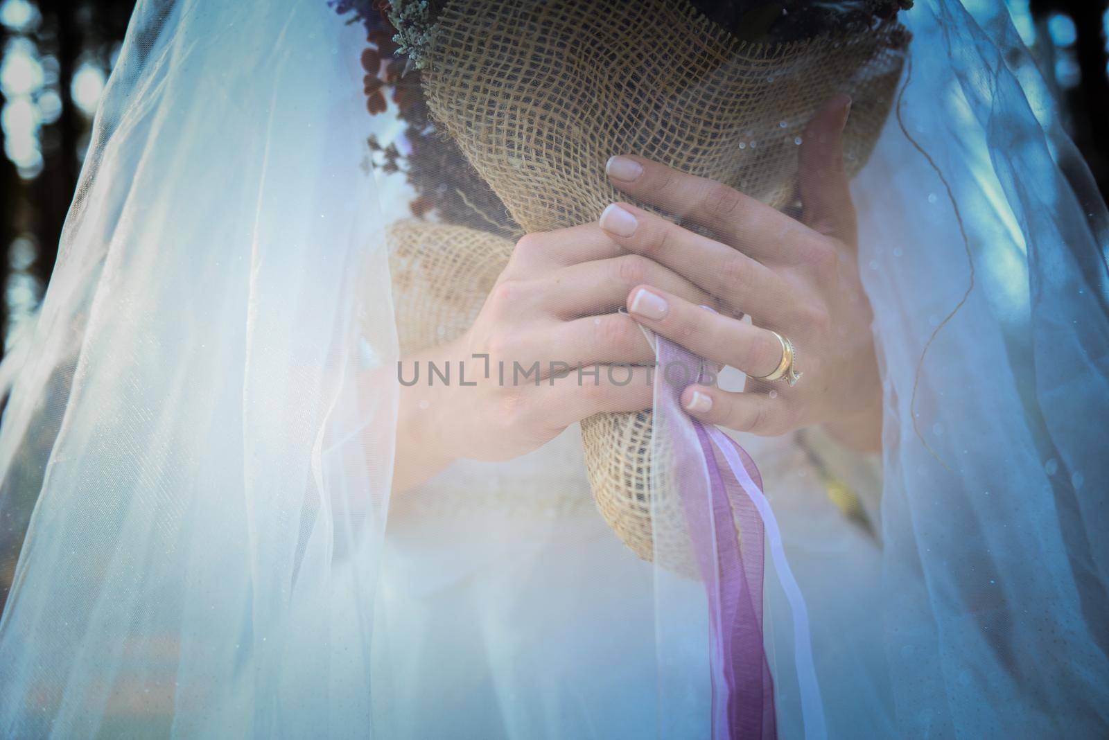 Bridal veil and diamond ring of the bride on her ring finger close up view