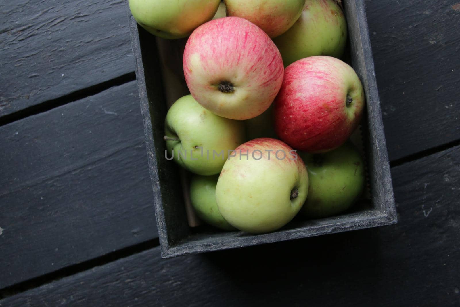 Ripe juicy apples in a retro wooden box on the table