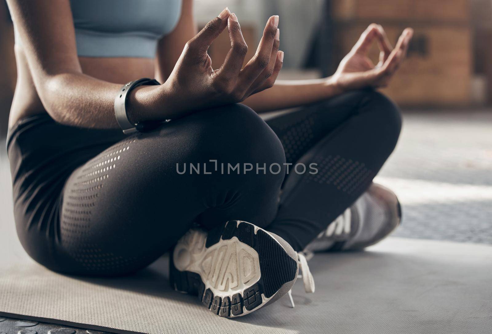 Make your day more zen. Closeup shot of an unrecognisable woman meditating in a gym. by YuriArcurs