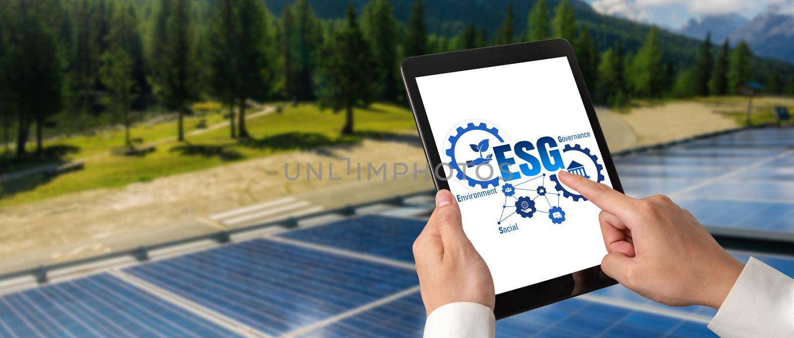 Green business transformation for environment saving and ESG business concept. Businessman using tablet to set corporate goal toward environmental friendly management and alternative clean energy use.