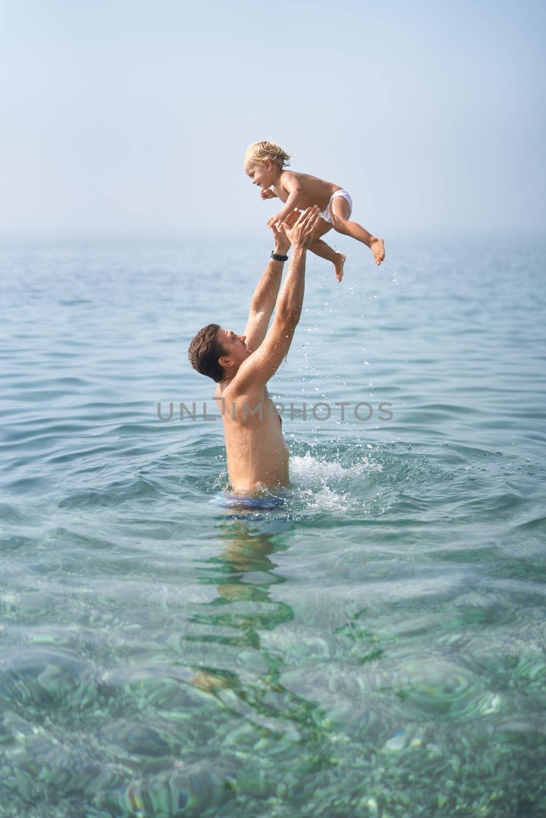 Dad throws a little girl into the sea by Nadtochiy