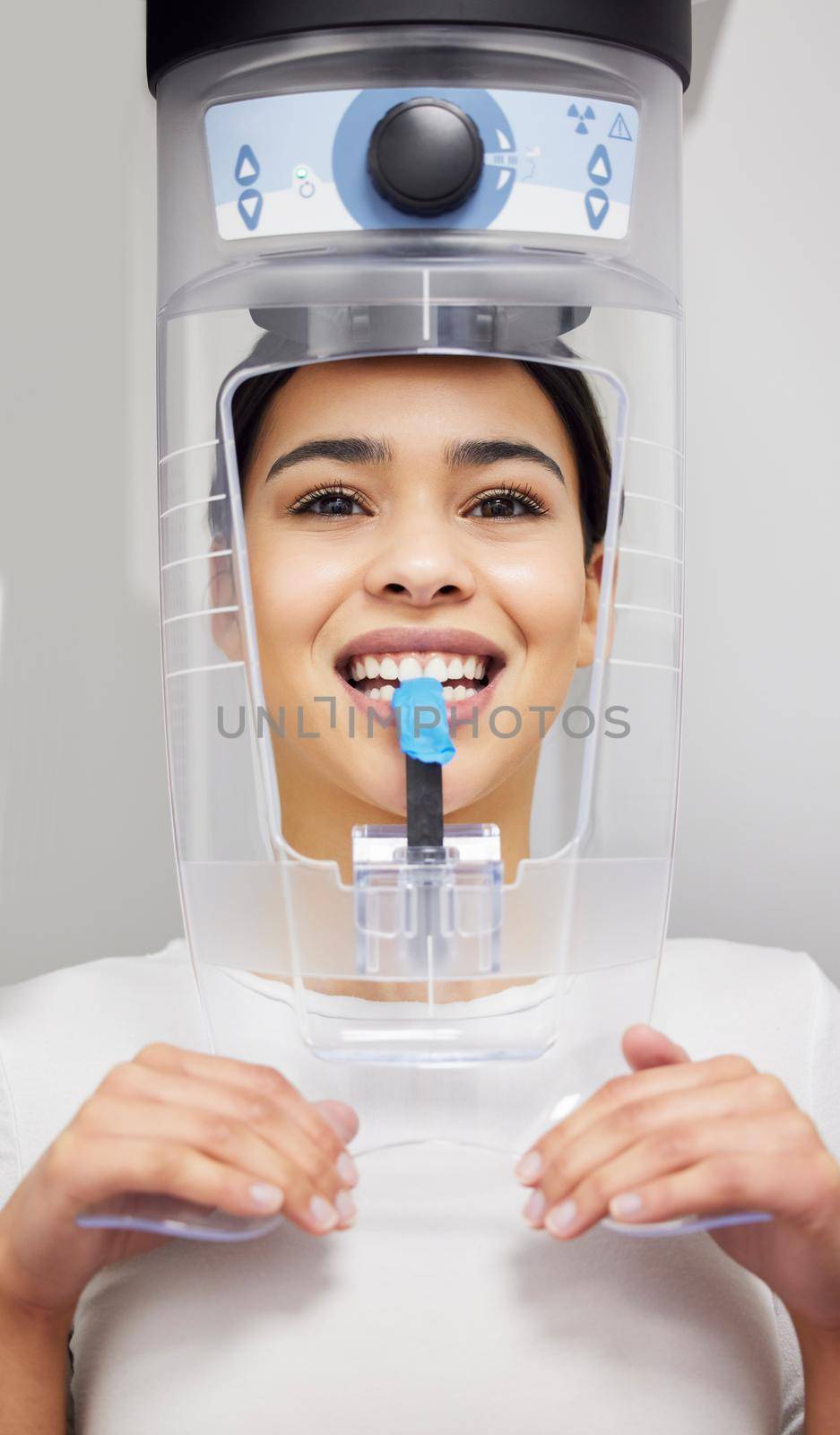 X-rays are a standard procedure at the dentist. a young woman using an x ray machine at a dentists office. by YuriArcurs