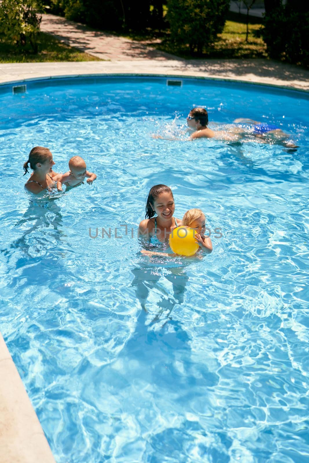 Mothers with young children swim in the pool. High quality photo