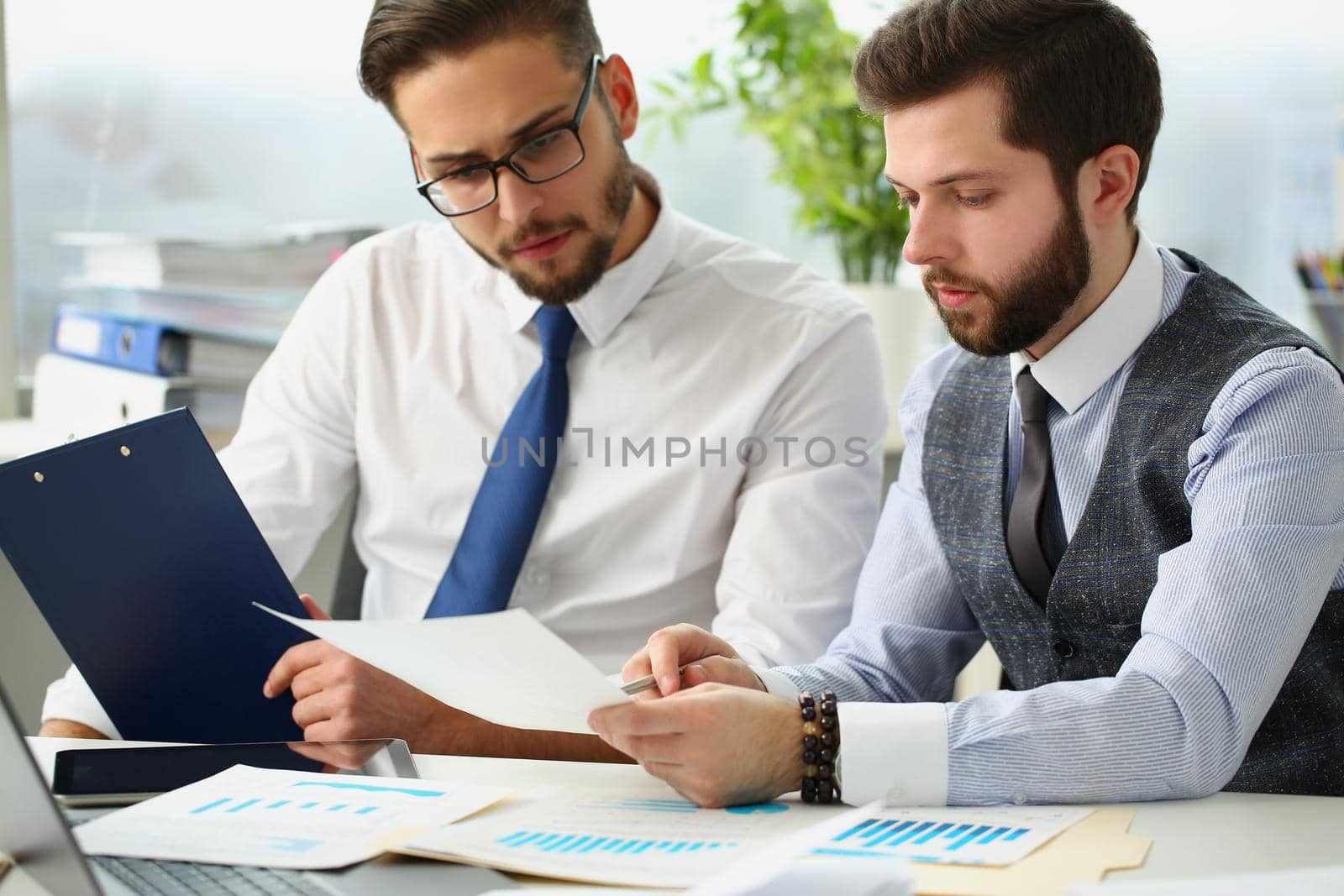Portrait of coworkers men go through financial papers, solve and discuss problems. Fresh look on situation, new angle, white collar. Investment concept