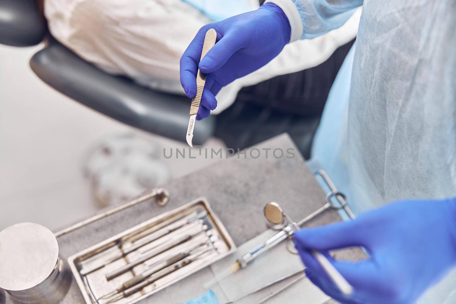 Confident doctor is preparing a scalpel for dental operation