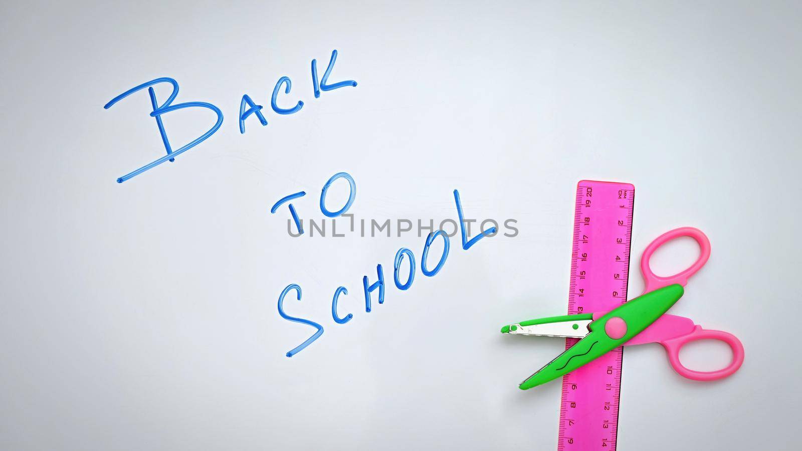 Back to school. Written on a white board with school supplies.