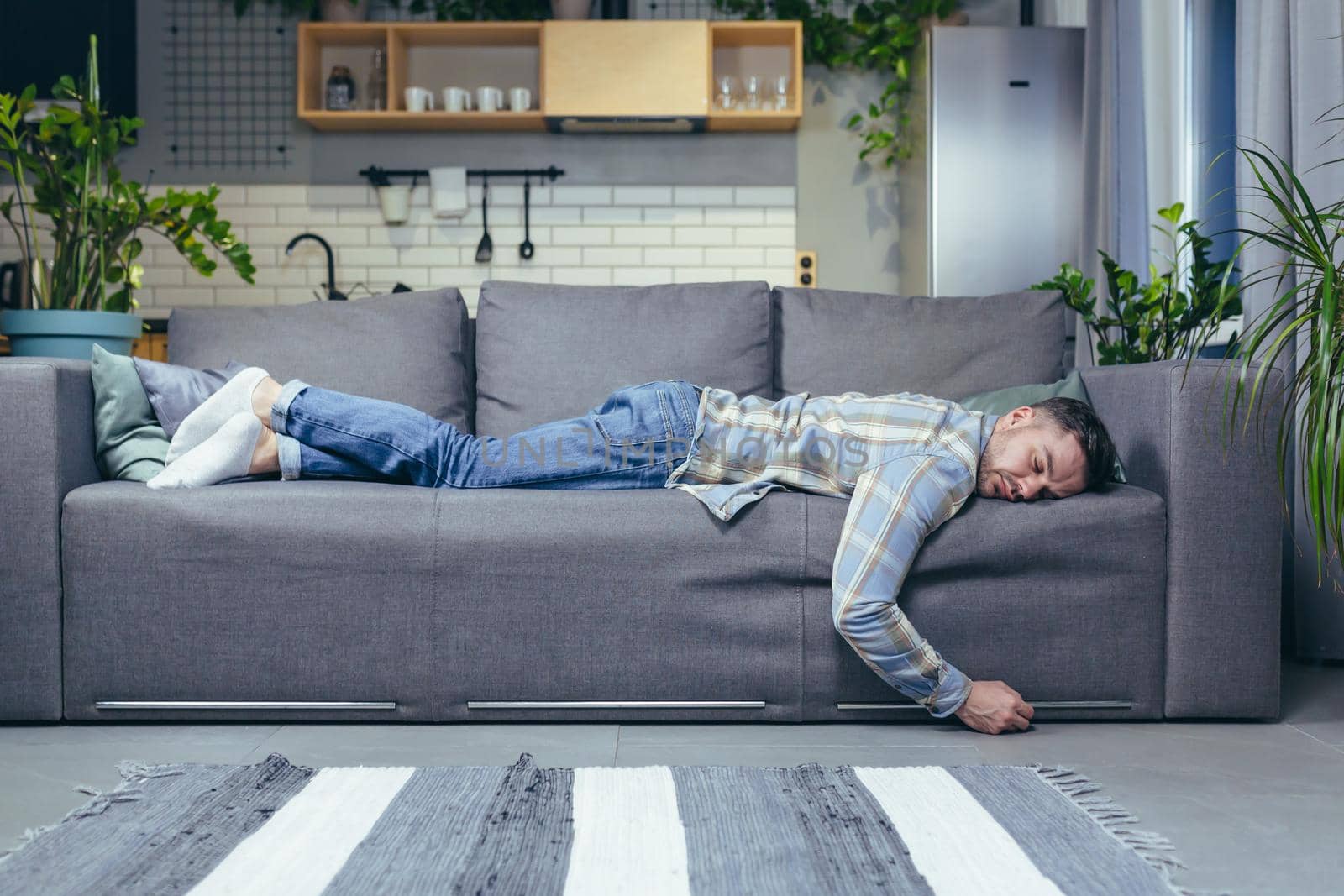 Depressed man tired after work sleeping on sofa at home
