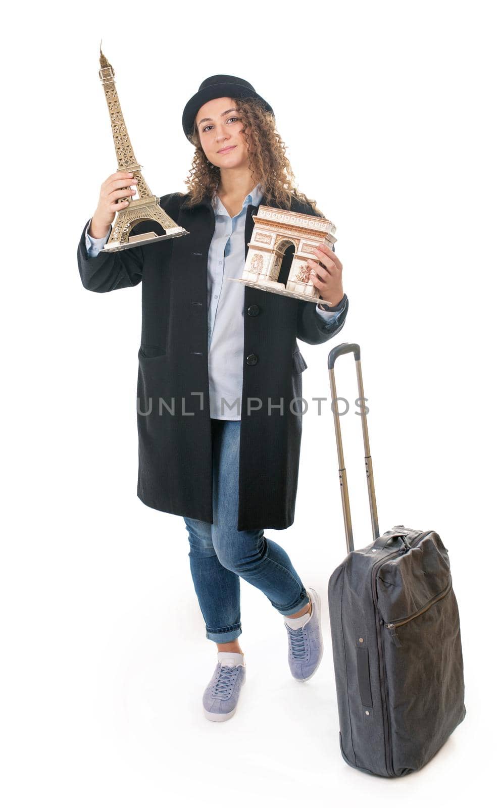 young girl with travel bag holds the symbols of France, the model of the triumphal arch and the triumphal arch on a white background by aprilphoto