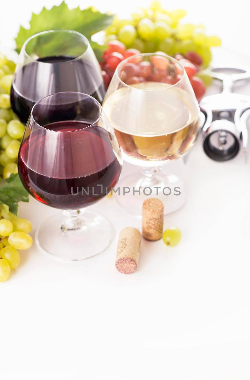 glasses of red and white wine and ripe grapes on table