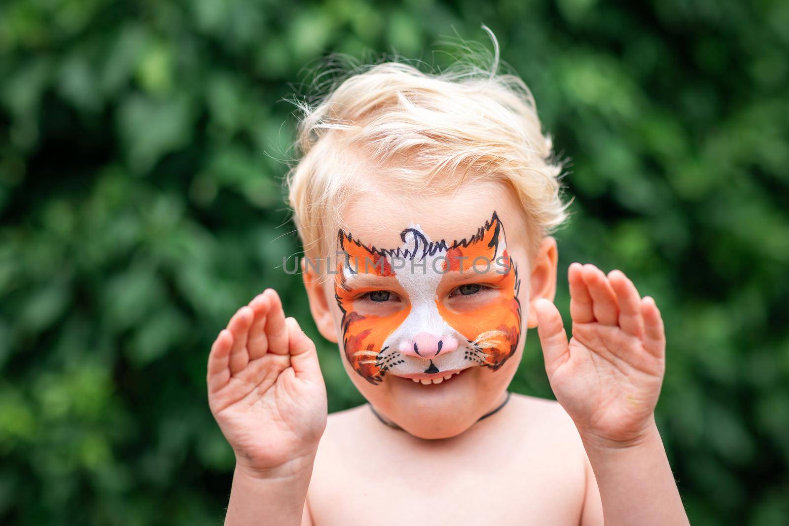 Cute little boy with face paint. Face painting, kid painting face at the birthday party or on holidays