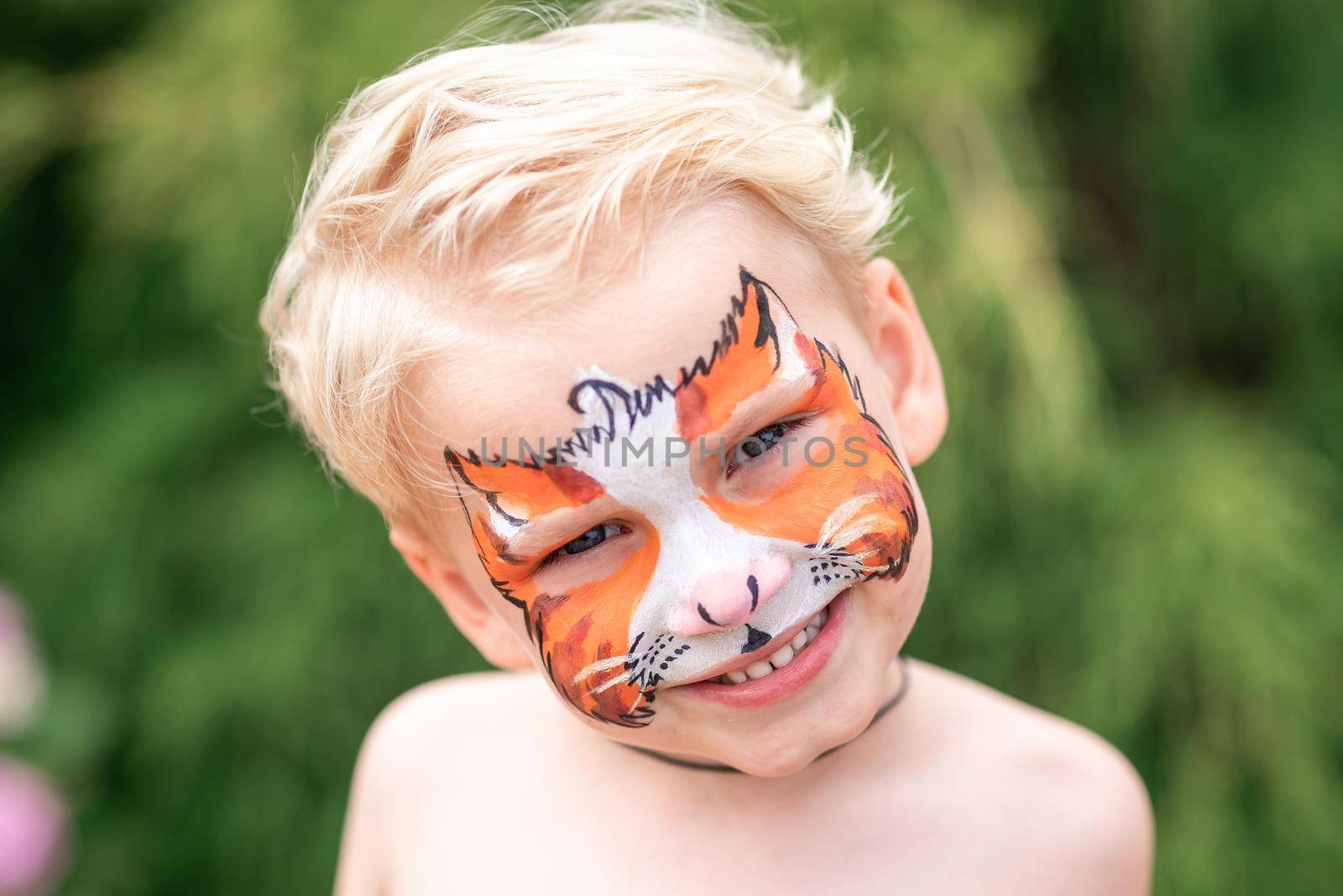 Cute little boy with face paint. Face painting, kid painting face at the birthday party or on holidays