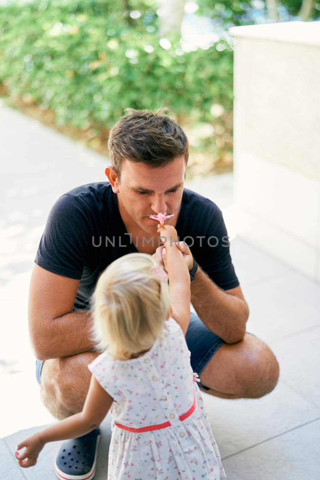 Little girl gives her father a flower by Nadtochiy