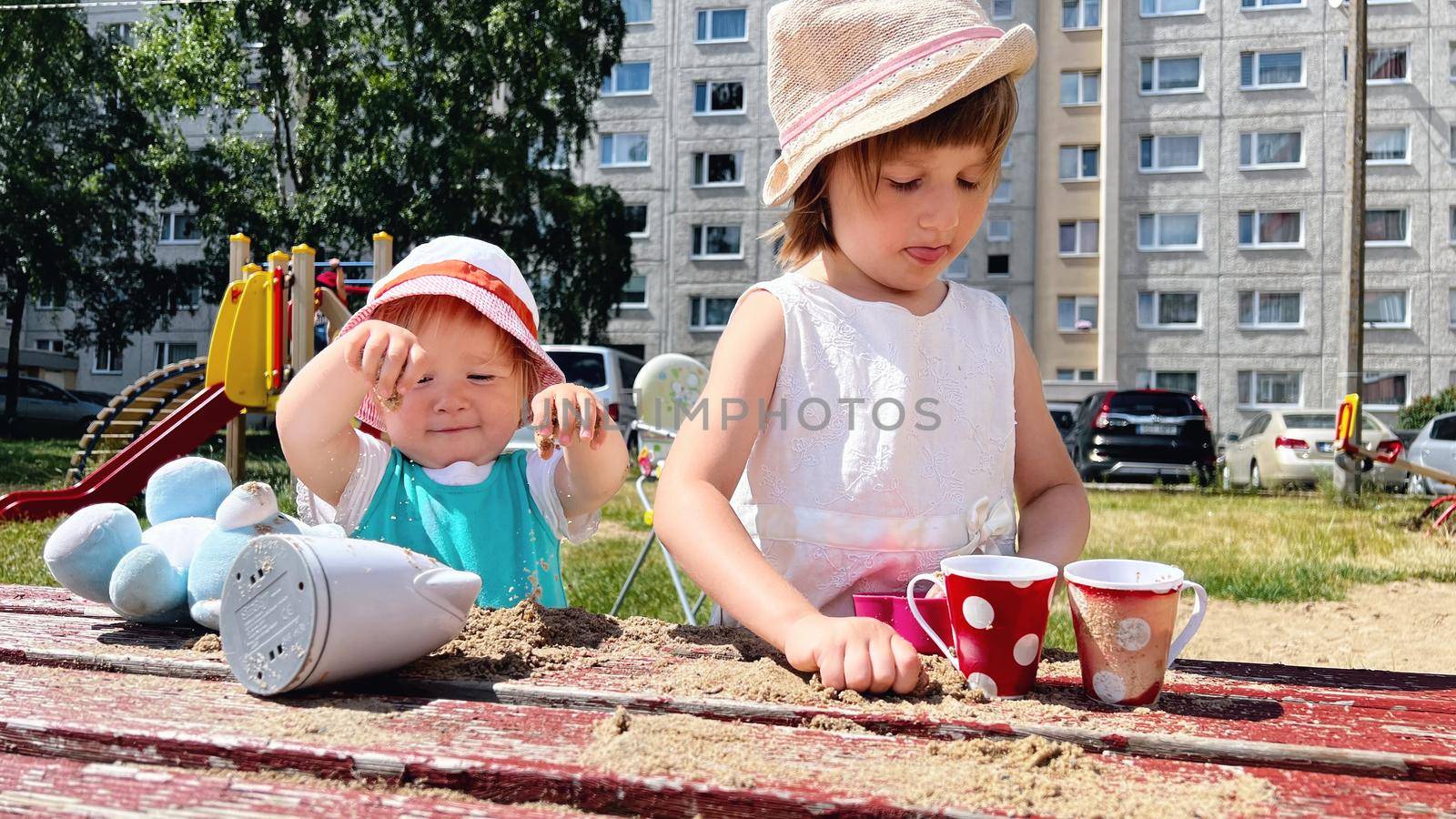 Two girls playing at playground at backyard of blocks of flats by Varaksina