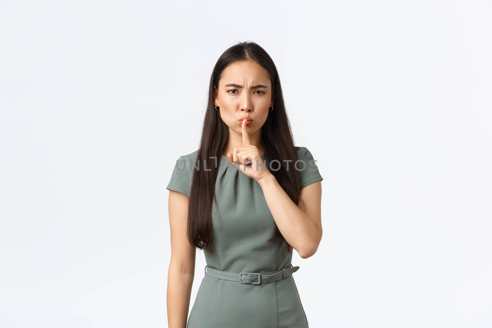 Small business owners, women entrepreneurs concept. Strict serious-looking hushing, say shh and press index finger to lips, telling stay quiet, demand silence or hold mouth shut, white background.