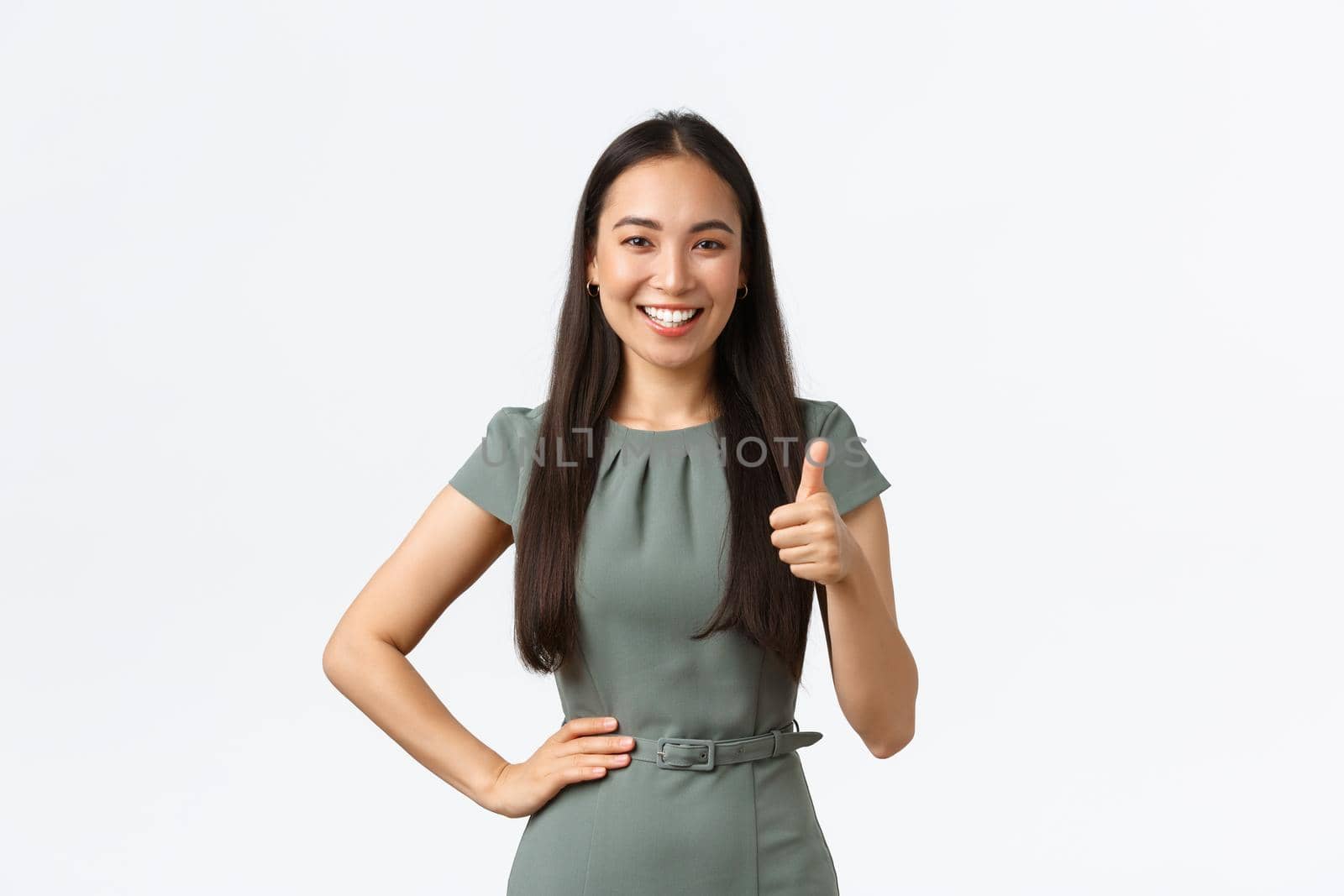 Small business owners, women entrepreneurs concept. Satisfied smiling asian female team leader praising great job, showing thumbs-up in approval, like result, white background.