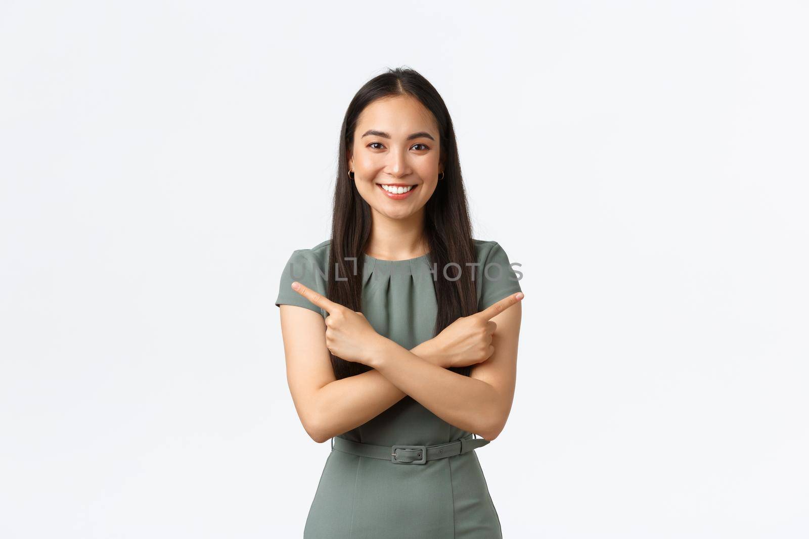 Small business owners, women entrepreneurs concept. Smiling pretty asian woman asking help with making decision, pointing fingers sideways, showing left and right product banners, white background.