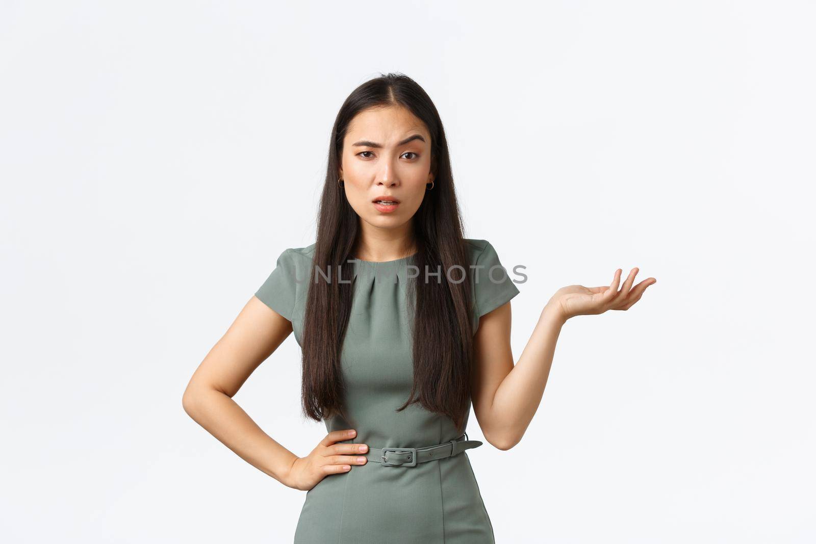 Small business owners, women entrepreneurs concept. Confused and annoyed asian businesswoman waiting for answers, asking so what, raising hand up questioned and looking impatient camera.
