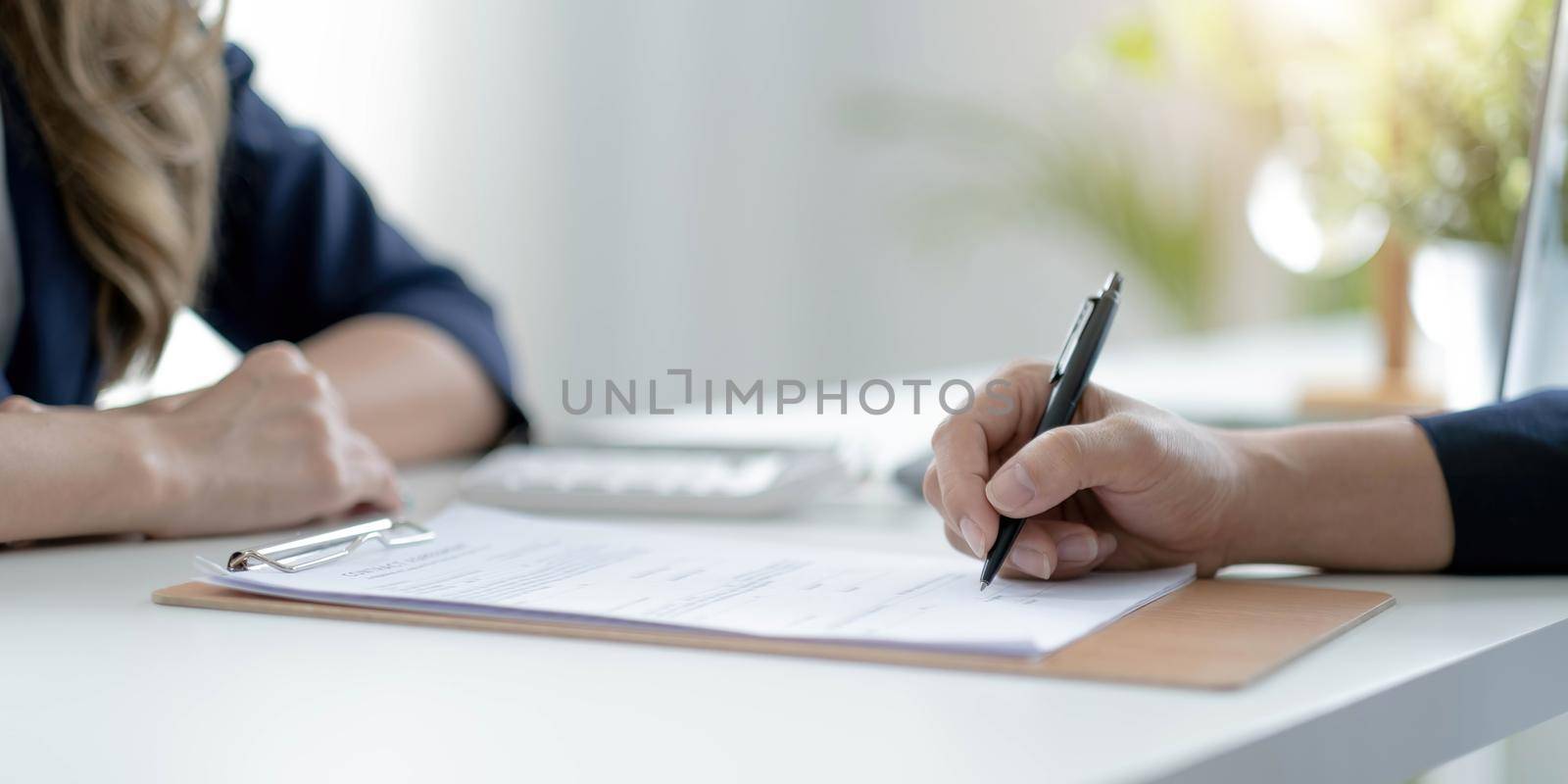 Close up of male hand putting signature, running own small business, have a contract in place to protect it, basics of writing contract, one sentence in a contract can cost a business. by wichayada