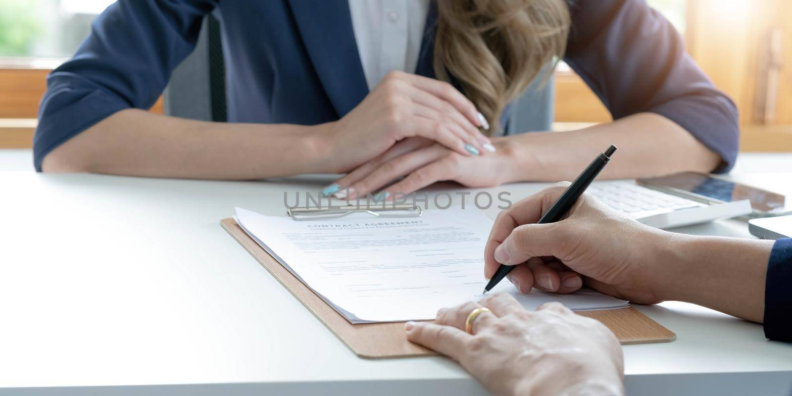 Close up of male hand putting signature, running own small business, have a contract in place to protect it, basics of writing contract, one sentence in a contract can cost a business. by wichayada