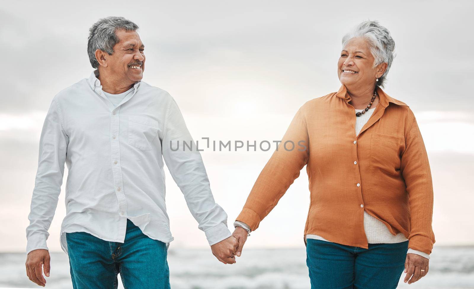 Romance never dies. an affectionate senior couple sharing an intimate moment on the beach. by YuriArcurs