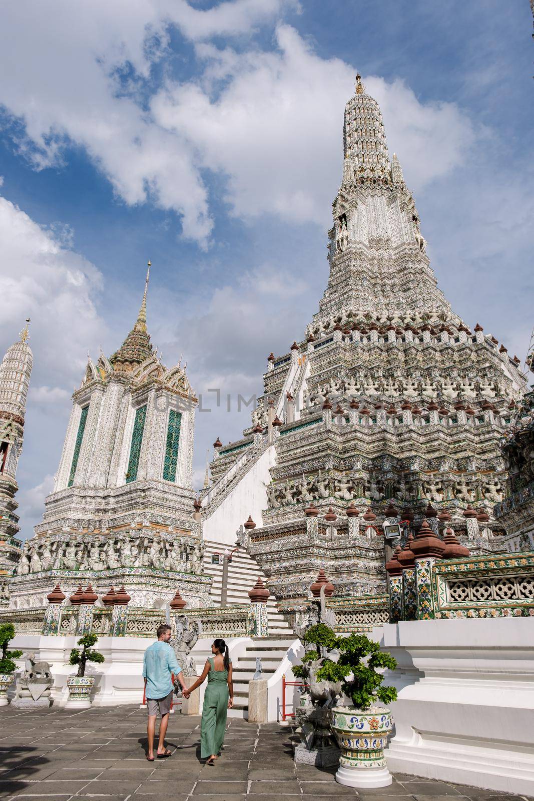 Wat Arun temple Bangkok Thailand, Temple of Dawn, Buddhist temple alongside Chao Phraya River.Beautiful Wat Arun at dusk evening sunset,couple Asian woman and European men visiting temple in Bangkok