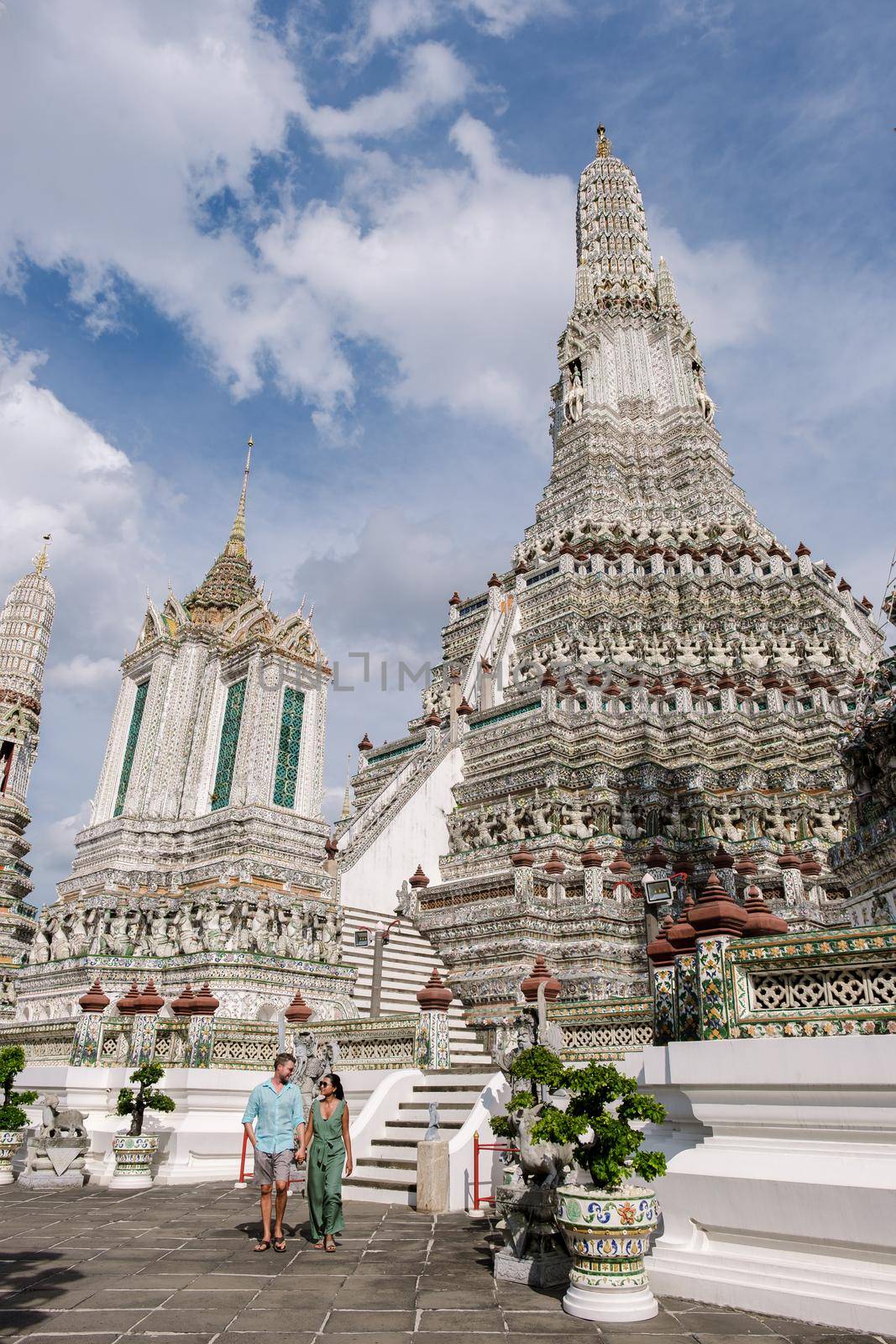 Wat Arun temple Bangkok Thailand, Temple of Dawn, Buddhist temple alongside Chao Phraya River.Beautiful Wat Arun at dusk evening sunset,couple Asian woman and European men visiting temple in Bangkok