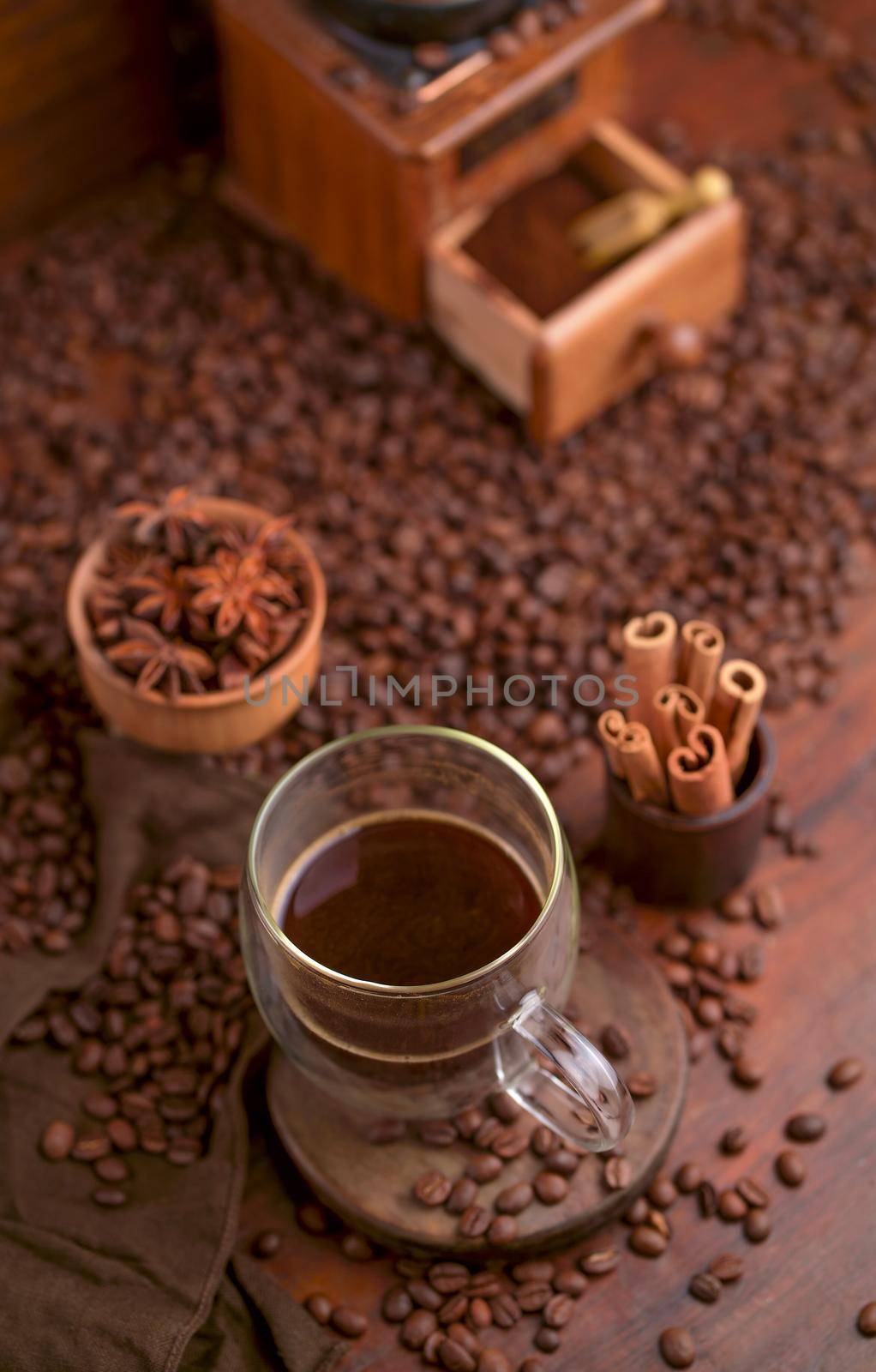 Tasty steaming espresso in cup with coffee beans. View from above. Dark background.