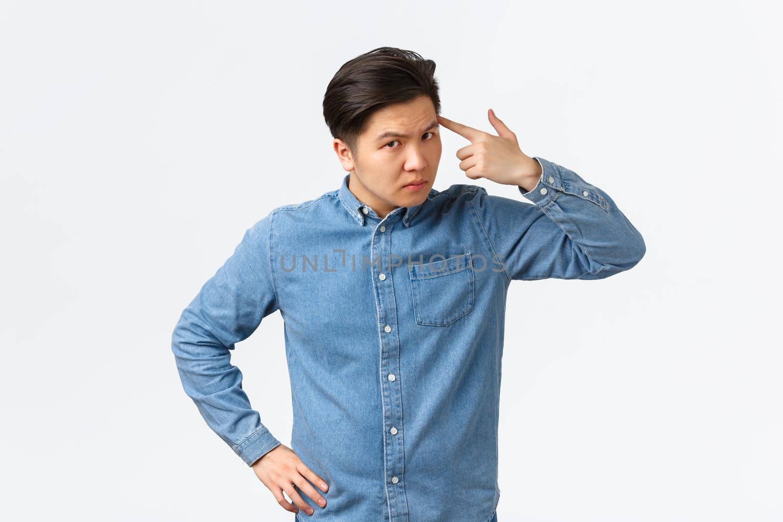 Serious angry asian man looking with dismay at employee, scolding person making stupid mistake, tap temple with finger and stare frustrated, standing white background upset by Benzoix